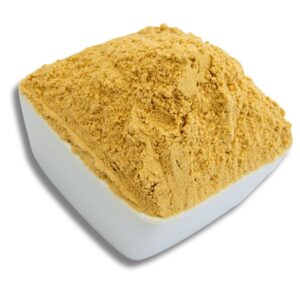 A white bowl filled with finely ground ginger powder, showcasing its golden color and texture.