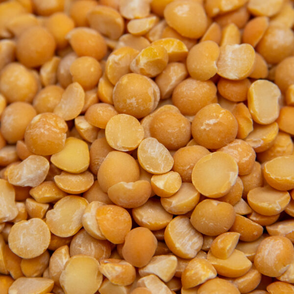 Yellow split peas close-up – dry, uncooked legumes in bulk.