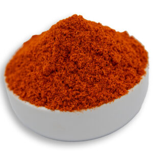 A white bowl filled with paprika ground, showcasing their smooth texture and deep orange color.